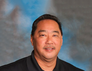 A man in black shirt and glasses smiling for the camera.