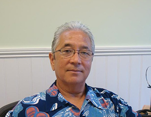A man with glasses and a hawaiian shirt.