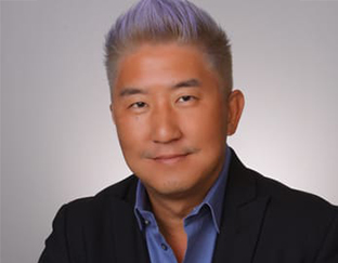 A man with purple hair and a blue shirt.