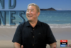A man standing on the beach with his hands in front of him.